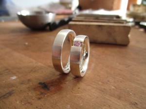Zwei Silberne Ringe. Der Rechte ist mit einem rosafarbenen Schmuckstein versehen.